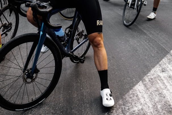 person in black shorts and white socks riding blue and black mountain bike