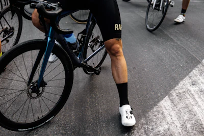 person in black shorts and white socks riding blue and black mountain bike