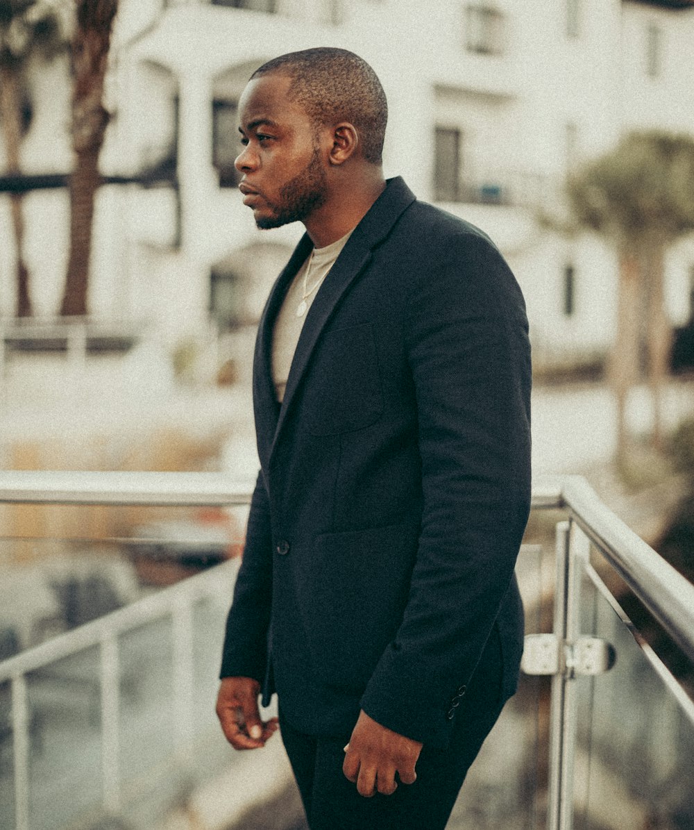 man in black suit standing on stairs