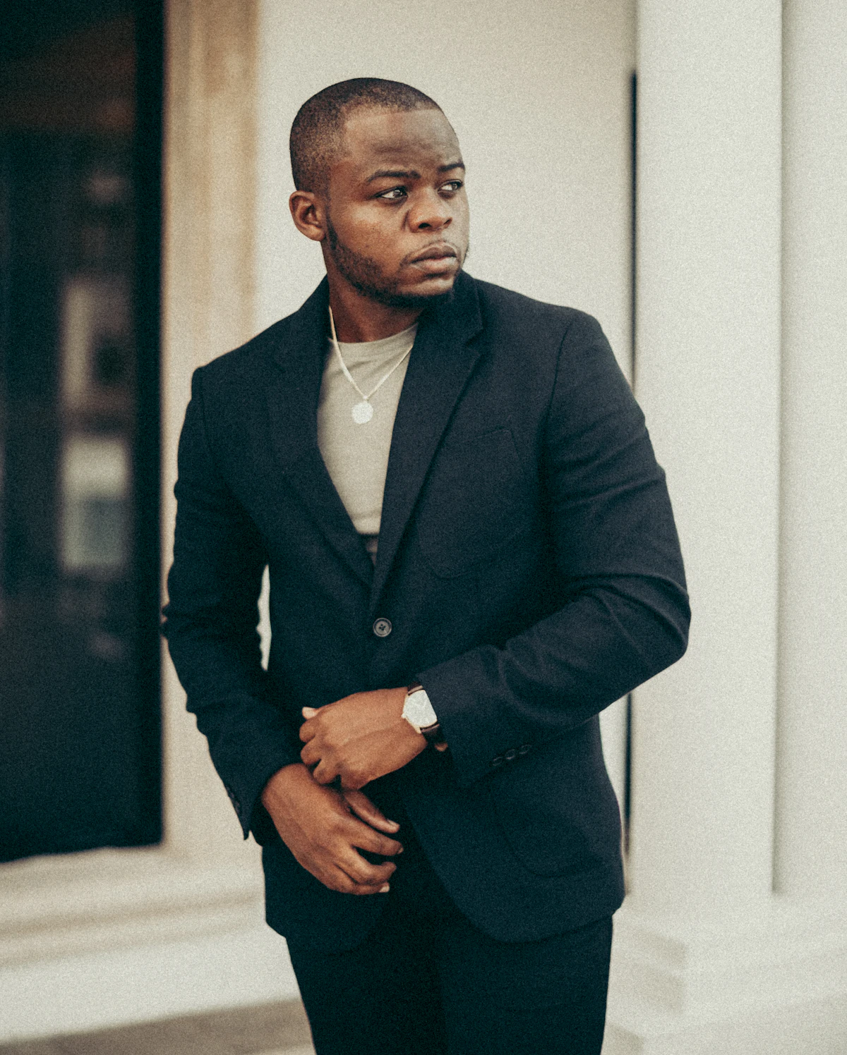 Man wearing a dark blazer over a neutral knit top for modern business casual styling