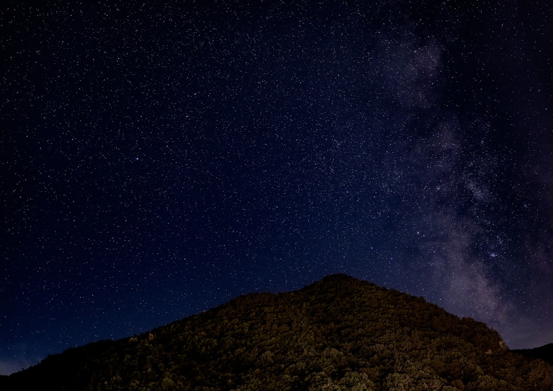 silhouette of mountain under blue sky during night time