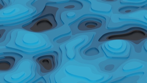 Layered abstract design featuring a series of curved and flowing shapes resembling a topographic map. Predominant use of blue hues with variations in shade creating a sense of depth.