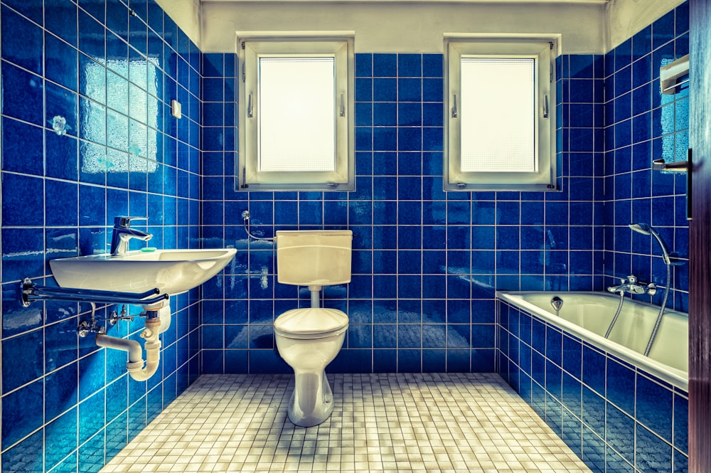 lavabo in ceramica bianca accanto a piastrelle da parete blu