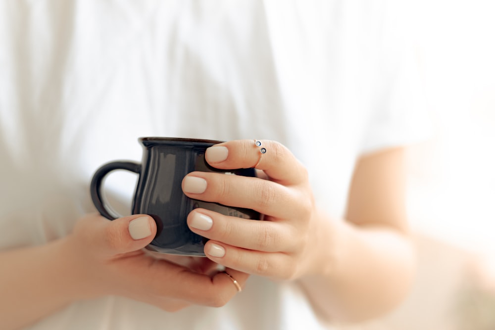 person holding black ceramic mug