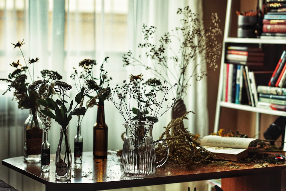 Fleurs blanches dans un vase en verre transparent sur une table en bois brun