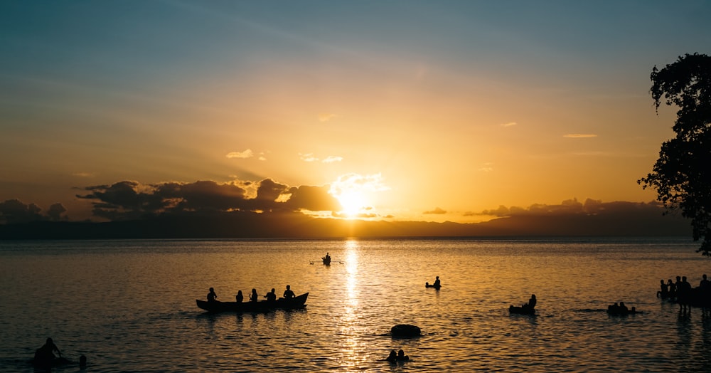 silhouette of people on boat during sunset