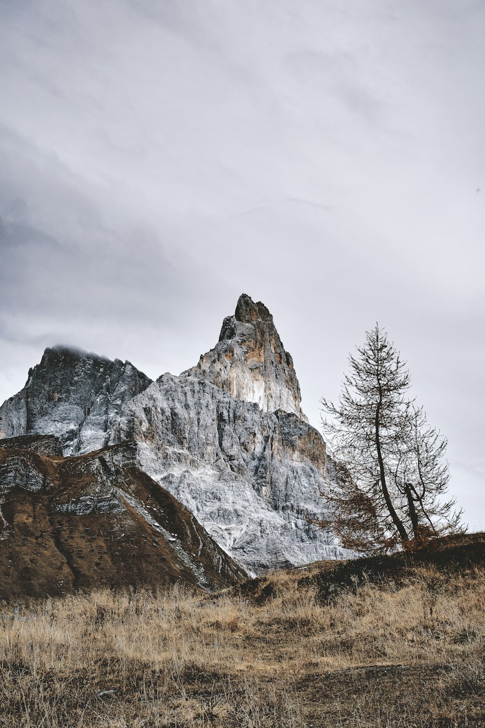 brown and white rocky mountain under gray cloudy sky