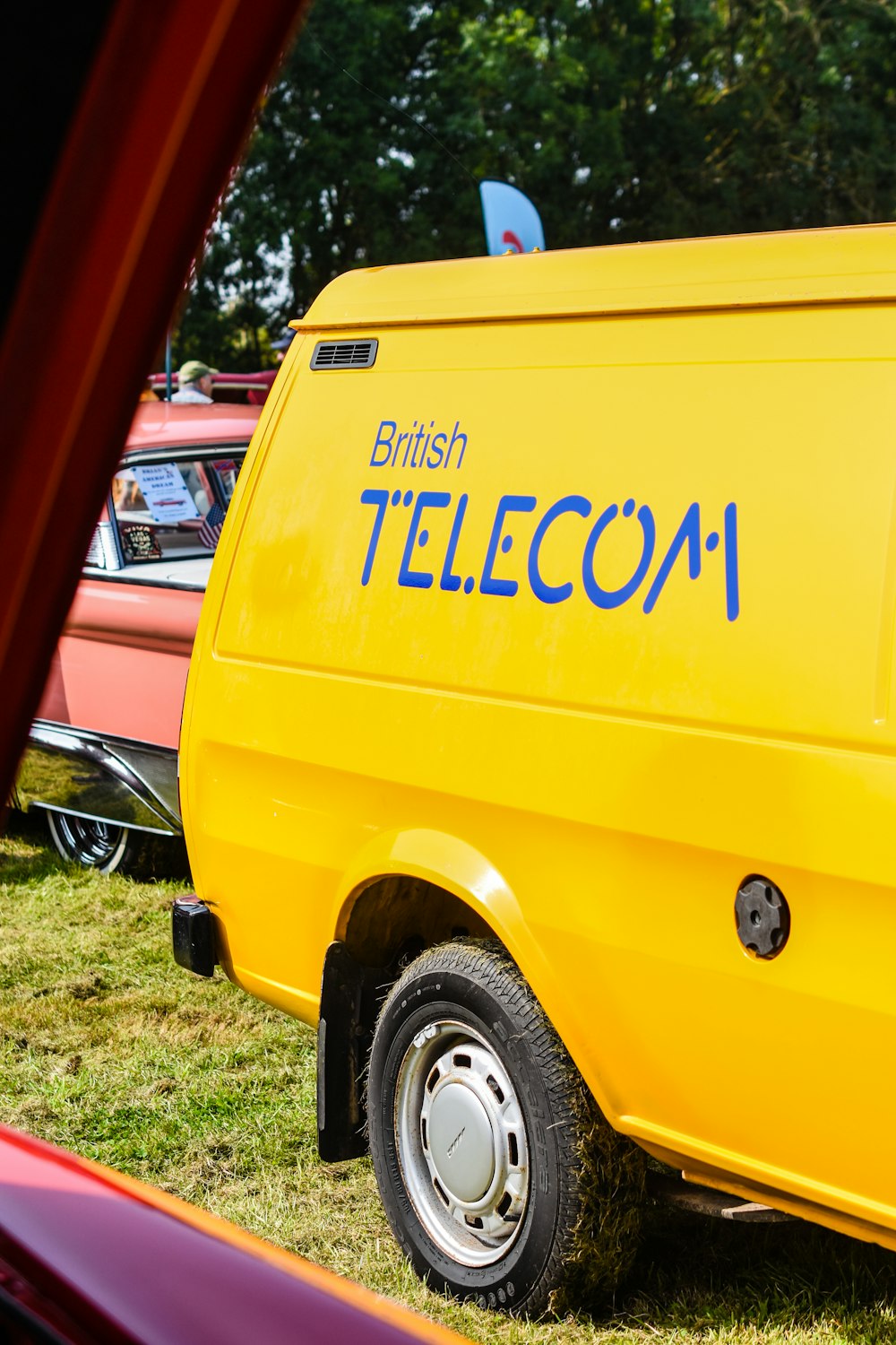 orange and white volkswagen t-2 parked on green grass field during daytime