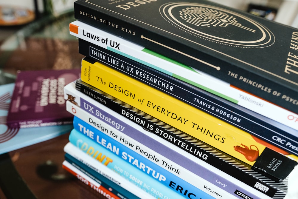 stack of books on brown wooden table