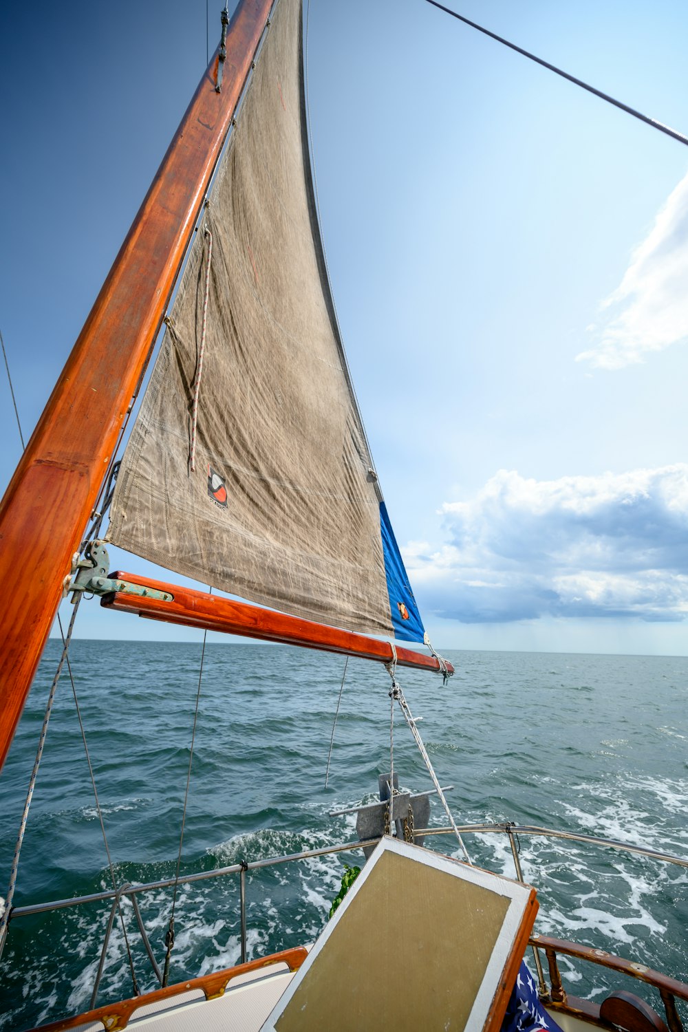 brown and white sailboat on sea under blue sky during daytime