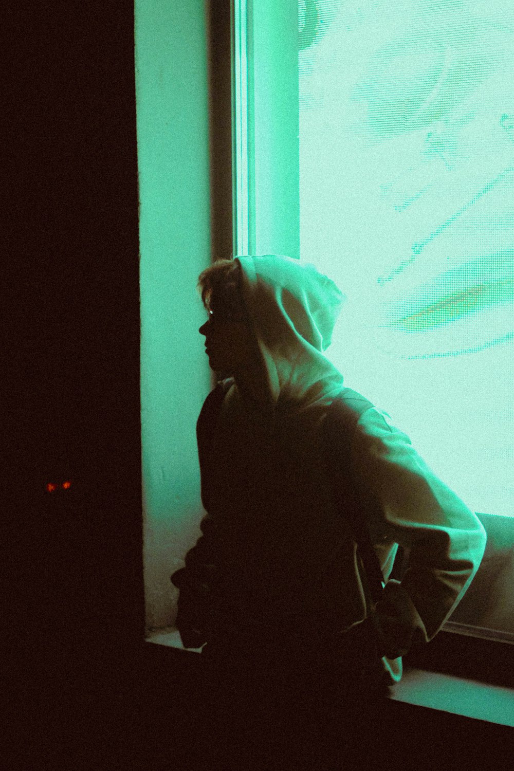 woman in black hoodie standing near white wall