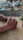 Hands using the verdevibe rolling kit on a wooden picnic table surrounded by greenery.