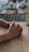Hands using the verdevibe rolling kit on a wooden picnic table surrounded by greenery.