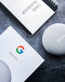 white google home mini on black table