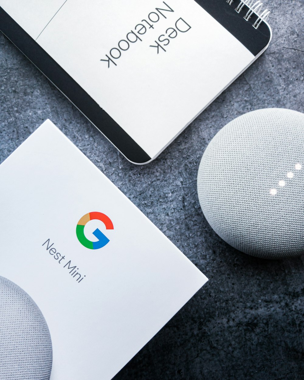 white google home mini on black table