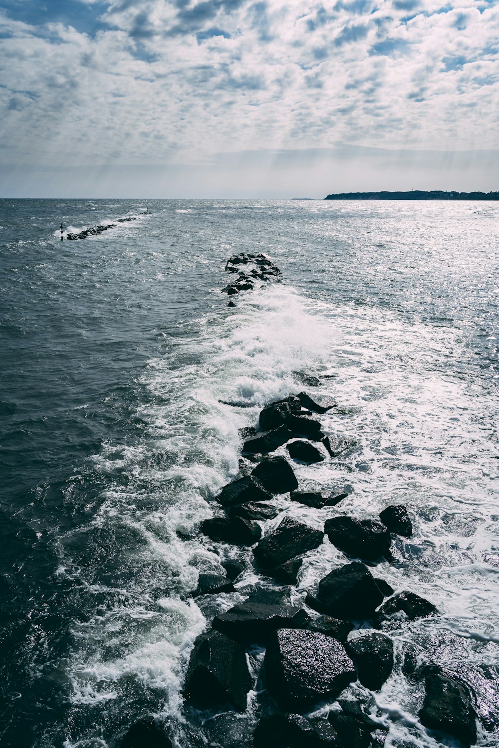 grayscale photo of sea waves crashing on rocks