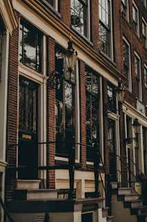 A historic brick building with large windows and a welcoming entrance.