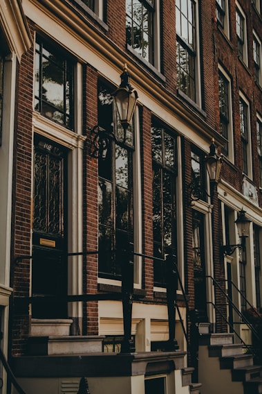 A historic brick building with large windows and a welcoming entrance.