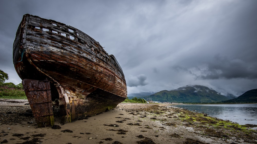 brown wooden boat on white sand during daytime