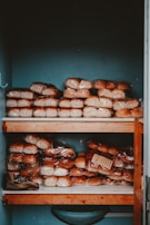 A wooden shelf filled with lots of donuts