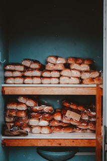 A wooden shelf filled with lots of donuts