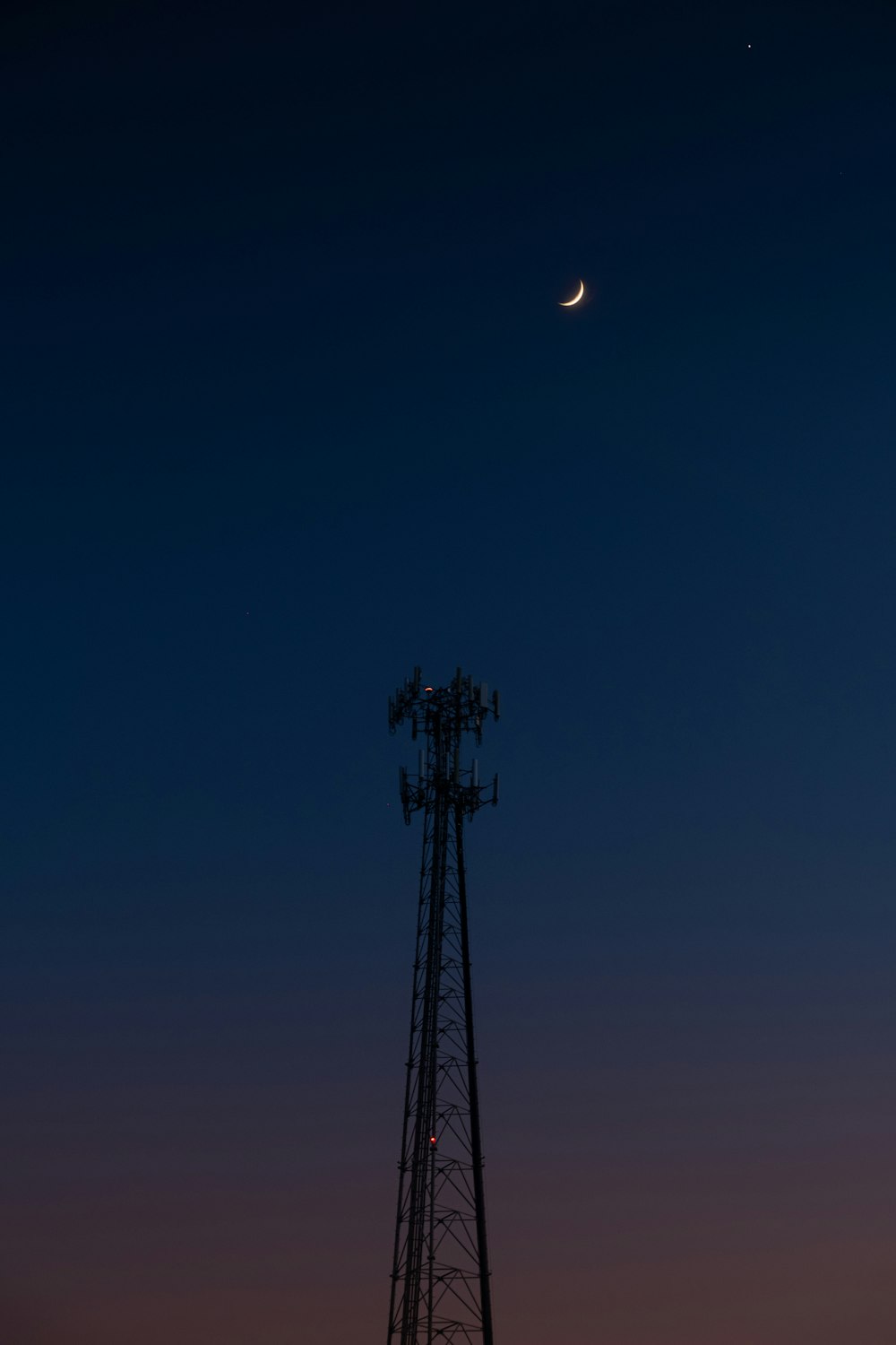 Schwarzer Metallturm unter blauem Himmel während der Nacht