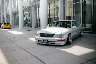 silver mercedes benz coupe parked near white building during daytime