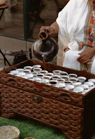 Traditional Somali tea being poured into small decorated glasses.