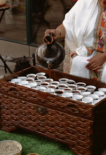 Traditional Somali tea being poured into small decorated glasses.