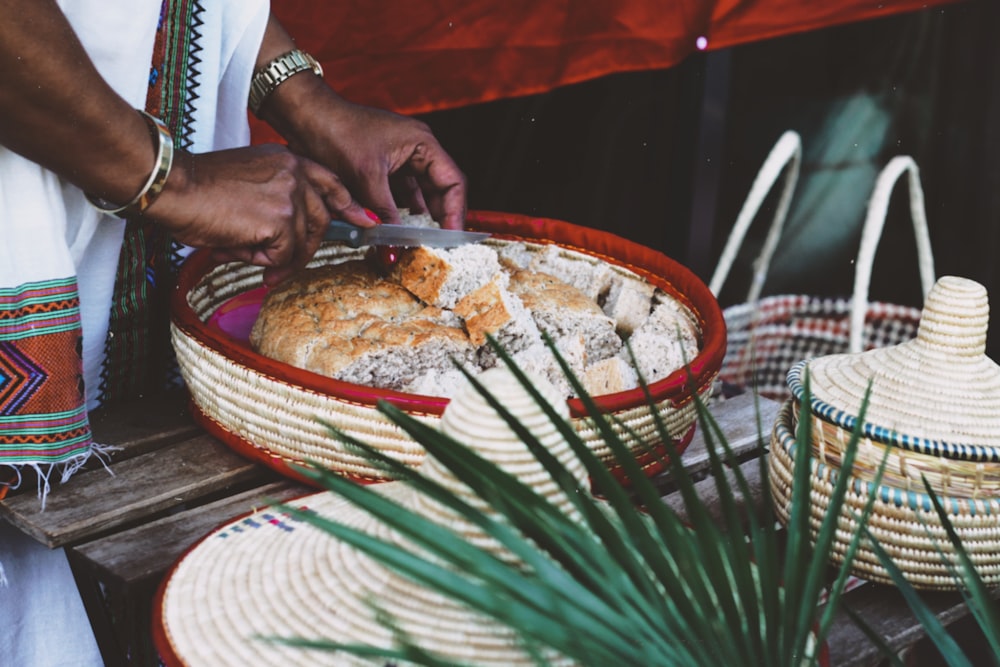 person in white shirt sitting on chair in front of table with food