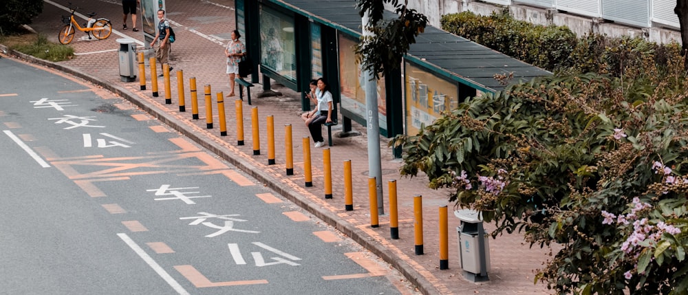 woman in black jacket and black pants standing on pedestrian lane during daytime