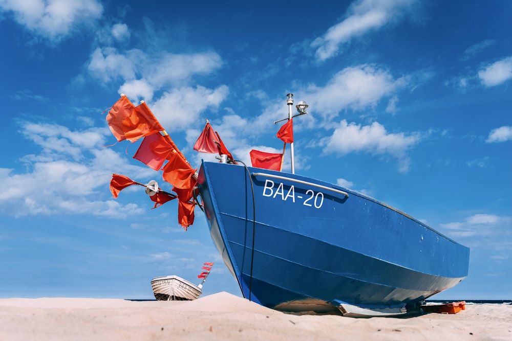 blue and white boat on beach during daytime