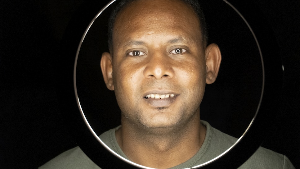 A professional headshot of a diverse team member in a circular frame.