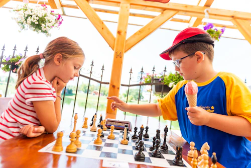 A boy in a blue shirt playing chess