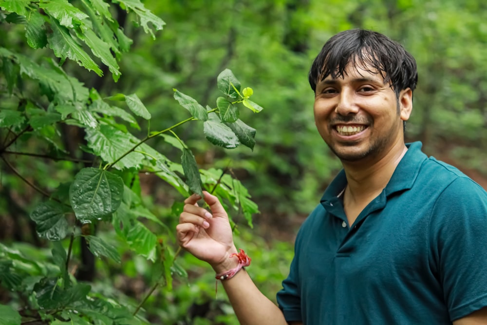 smiling woman in blue polo shirt holding green plant during daytime