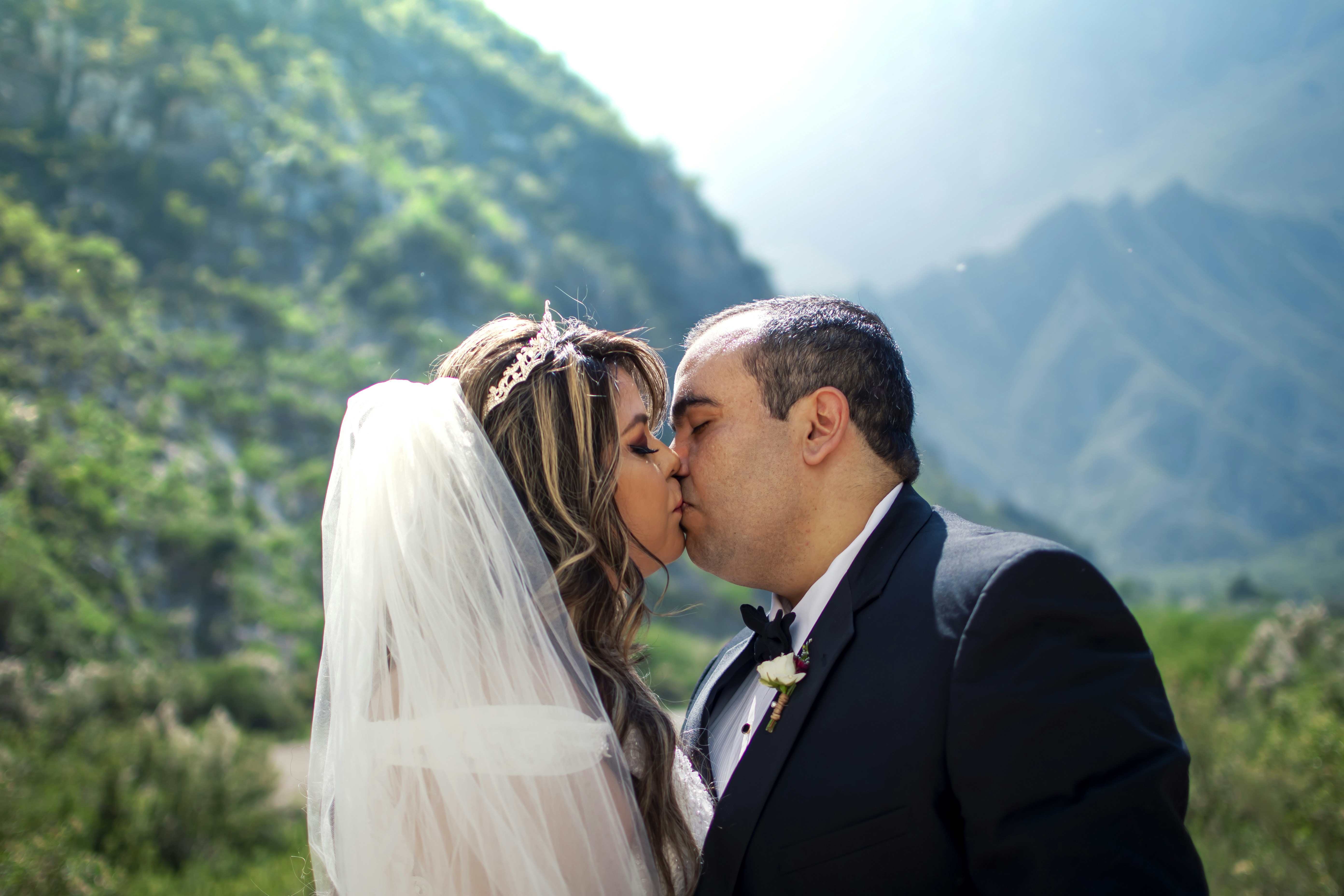 Man in black suit kissing woman in white wedding dress photo – Free ...