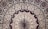 Intricate mandala pattern featuring a series of concentric circles adorned with floral and paisley motifs. The design includes heart-shaped elements filled with detailed floral patterns, primarily in shades of red, black, and white. The symmetry and repetition create a sense of balance and harmony.