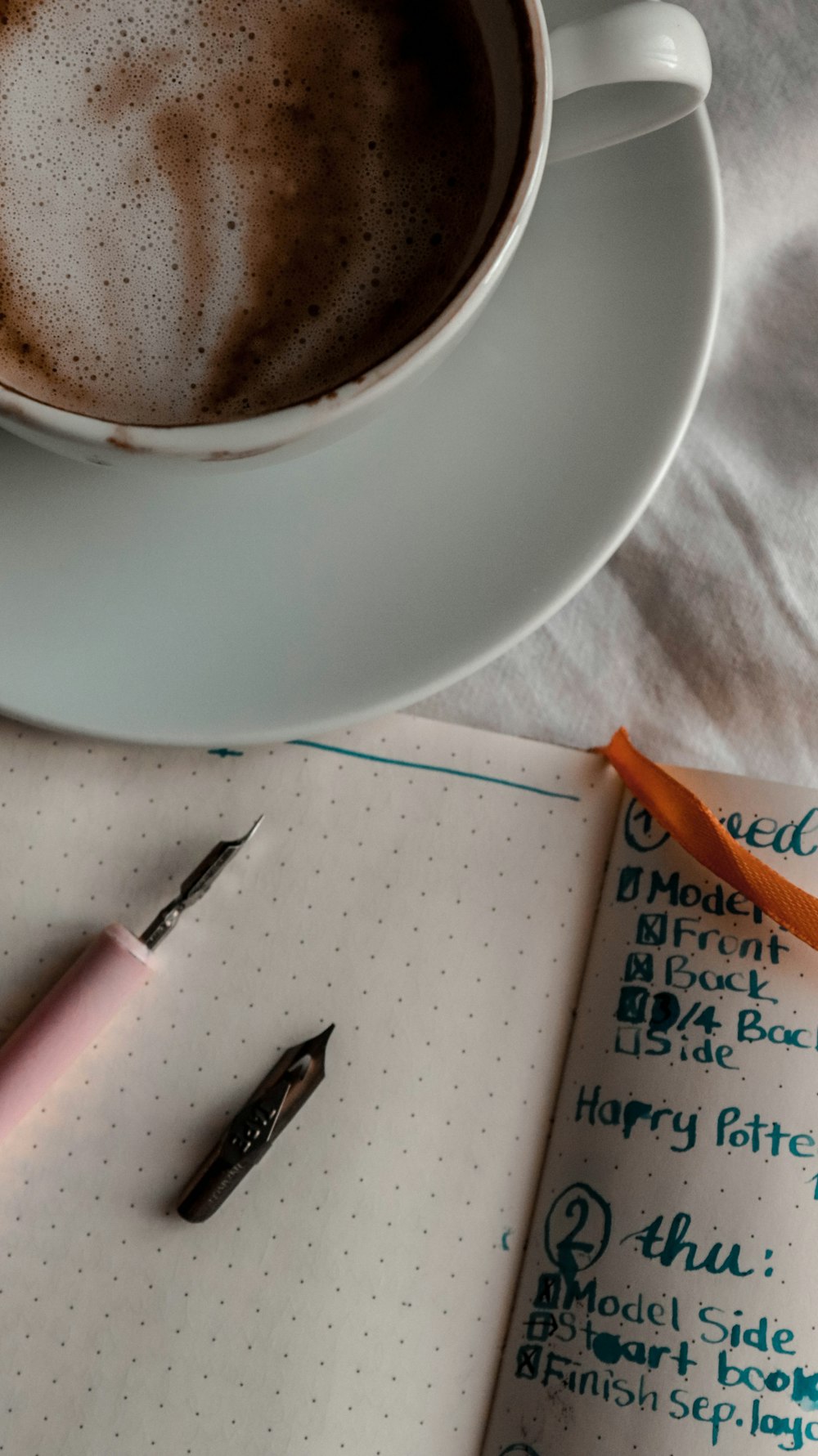 pink click pen beside white ceramic mug