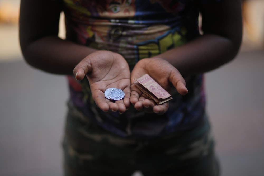 person holding brown and white round coins