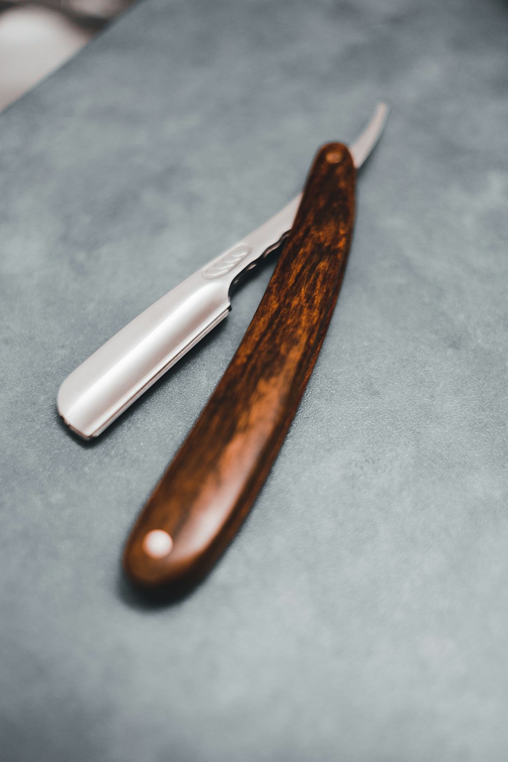 brown handle knife on blue textile