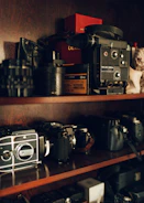 A camera lending library shelf filled with vintage and modern cameras.