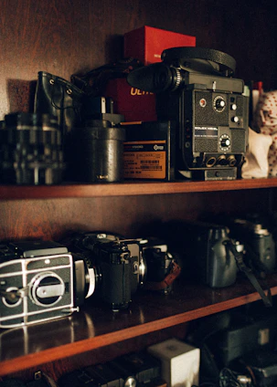 A cozy studio shelf displaying an array of cameras from vintage to modern models.