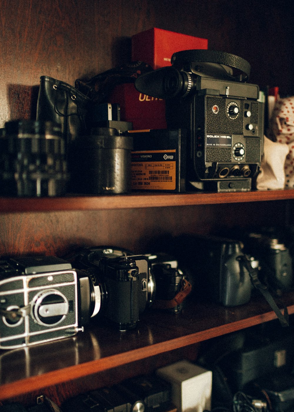 black and silver camera on brown wooden shelf