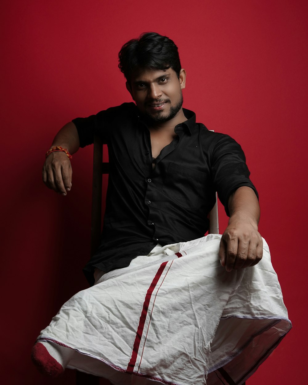 man in black polo shirt sitting on bed