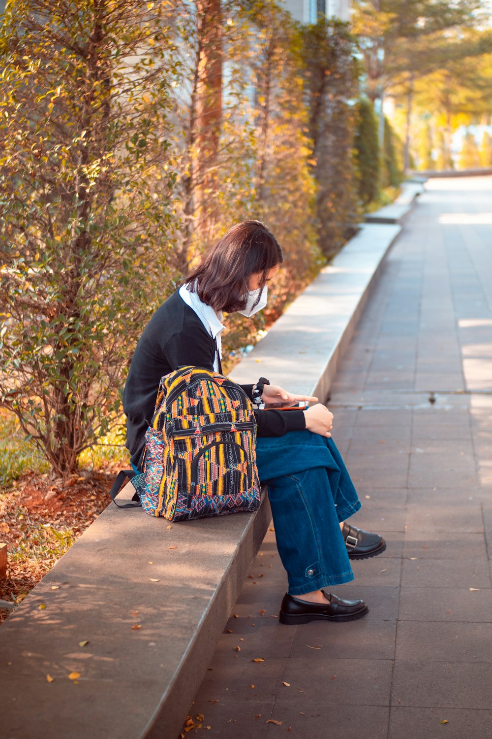 man in black suit sitting on sidewalk during daytime