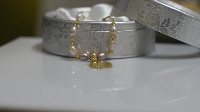 Elegant packaging box with celestial star patterns, slightly open to reveal a sparkling necklace inside.