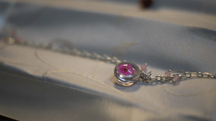 Close-up of a delicate 18k gold plated bangle with shimmering cubic zirconia stones resting on a soft velvet cushion.