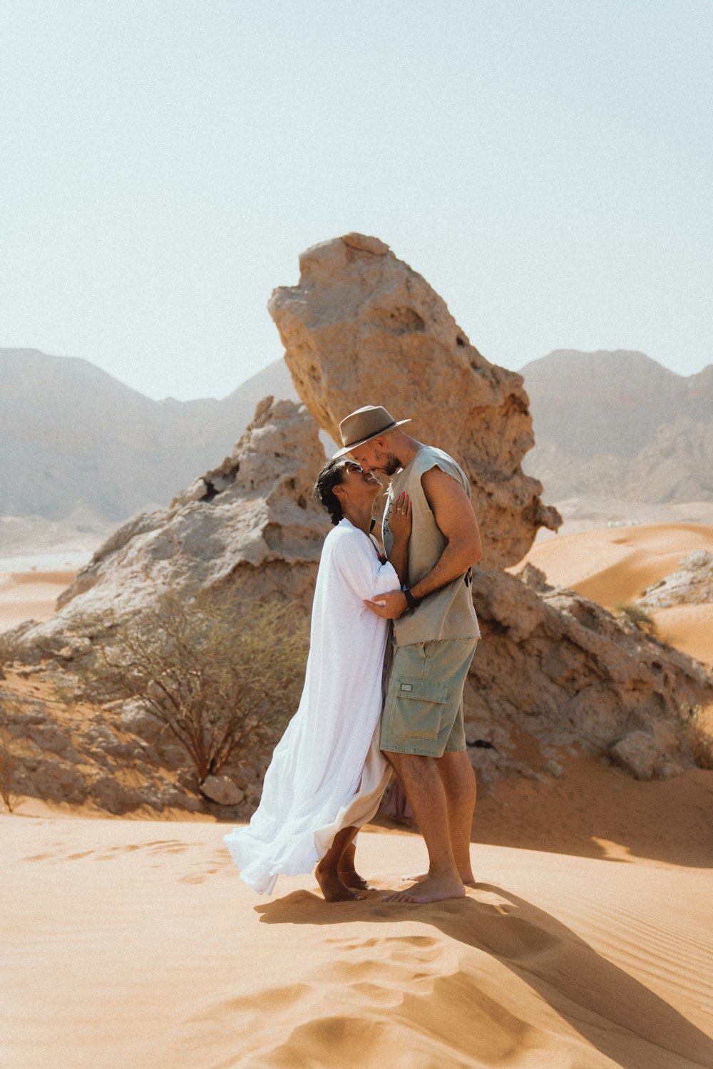 woman in white sleeveless dress standing on brown sand during daytime