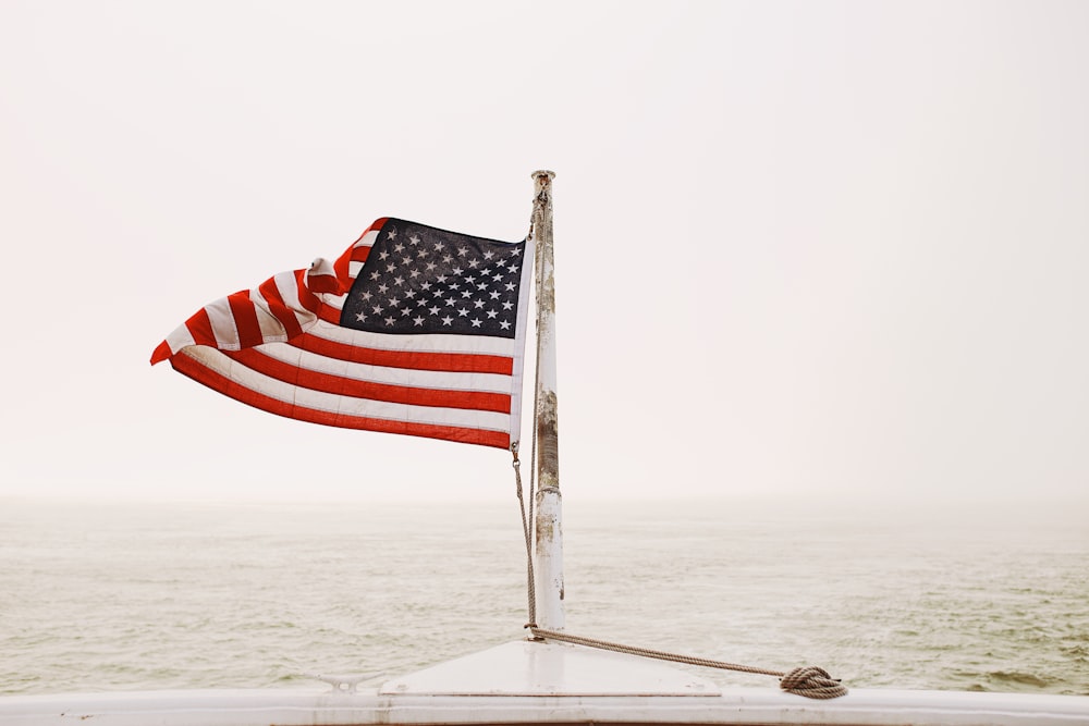 미국 낮 동안 하얀 모래에 흰 기둥에 깃발