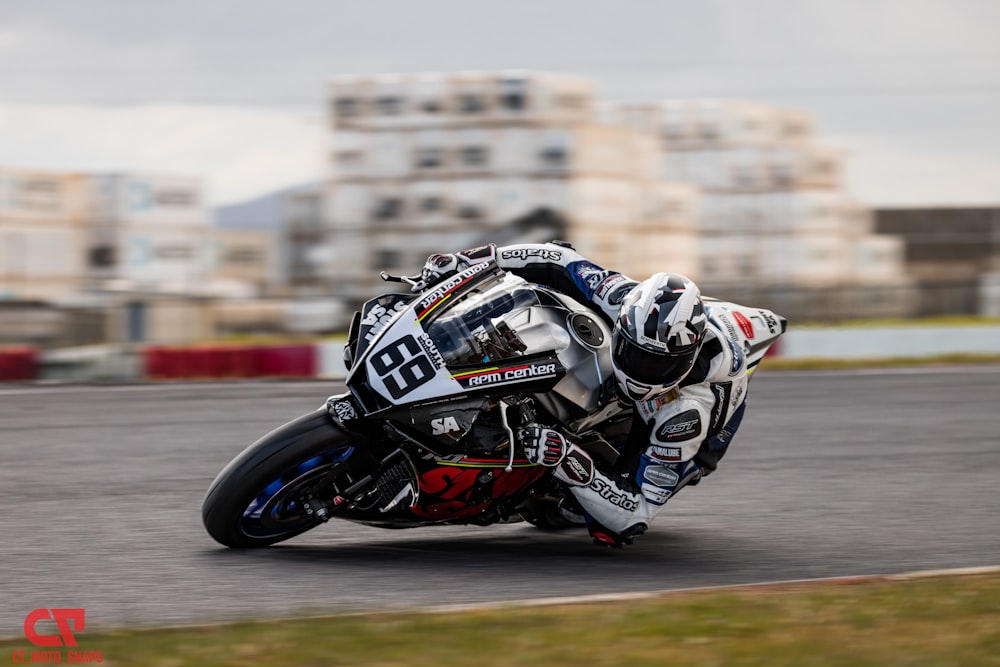 man in blue and white motorcycle suit riding on black and white sports bike